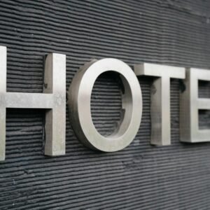 Close-up of a metallic hotel sign mounted on a textured wall.