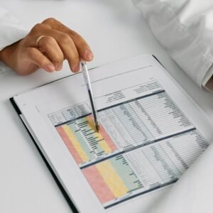 Doctor hands examining and pointing at medical charts in a close-up view.